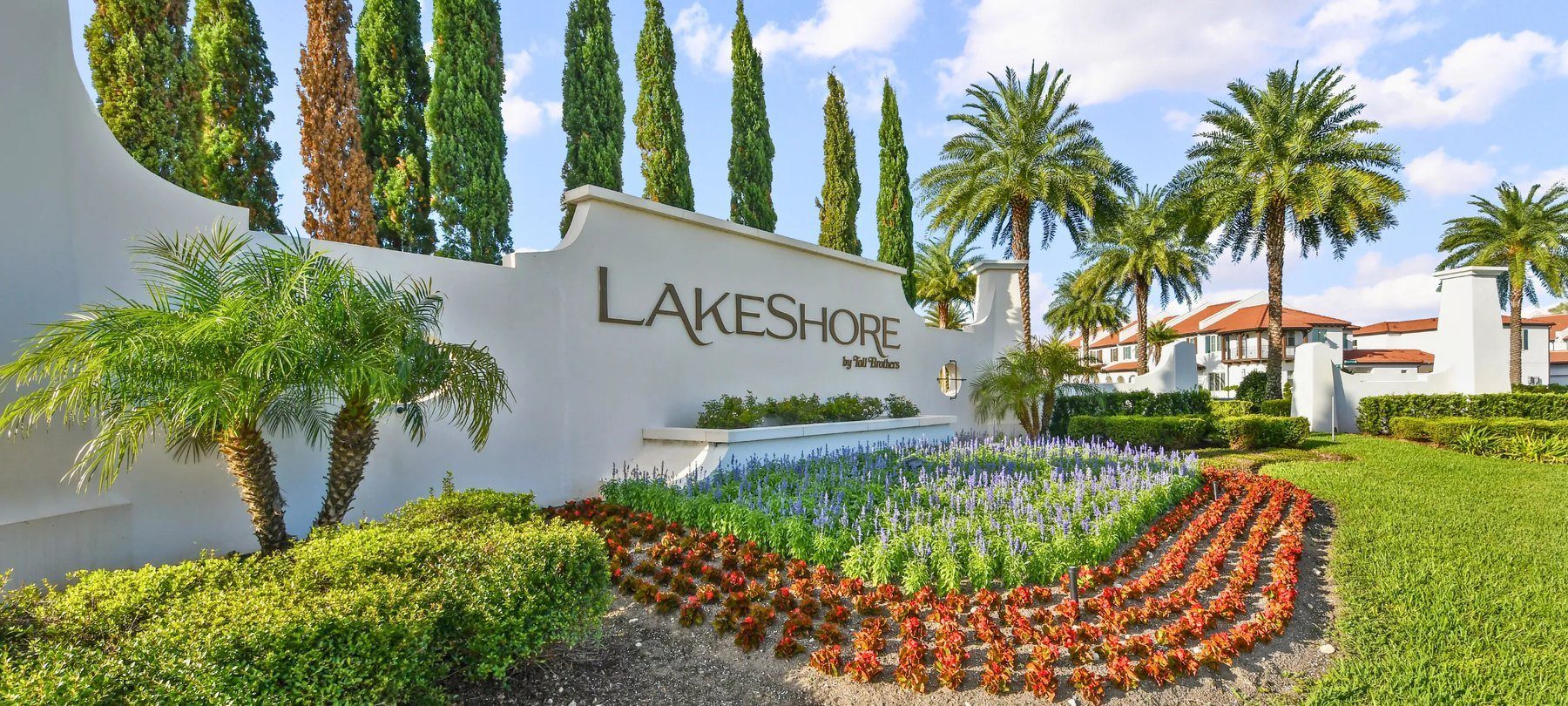 Entrada do bairro Lakeshore, com jardins e palmeiras
